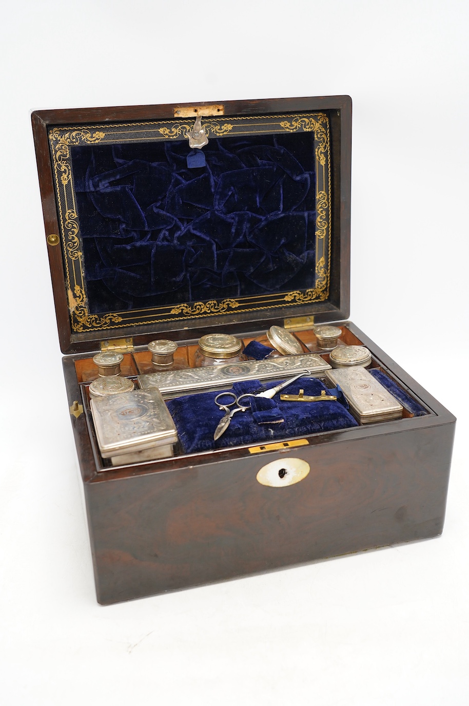 A Victorian rosewood toilet box with silver plate lidded bottles, ‘secret’ draw and leather case, 30cm wide. Condition - fair